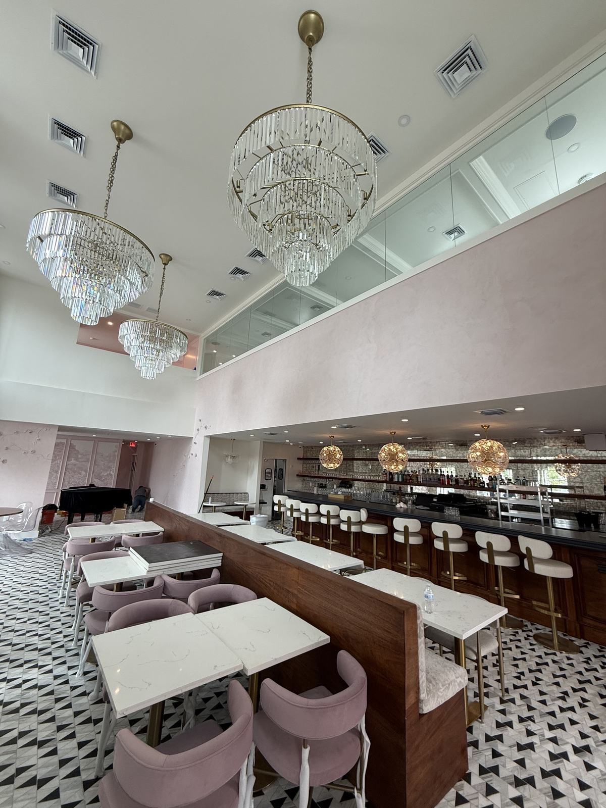 Commercial restaurant build-out with chandeliers, booth seating, and patterned tile floor